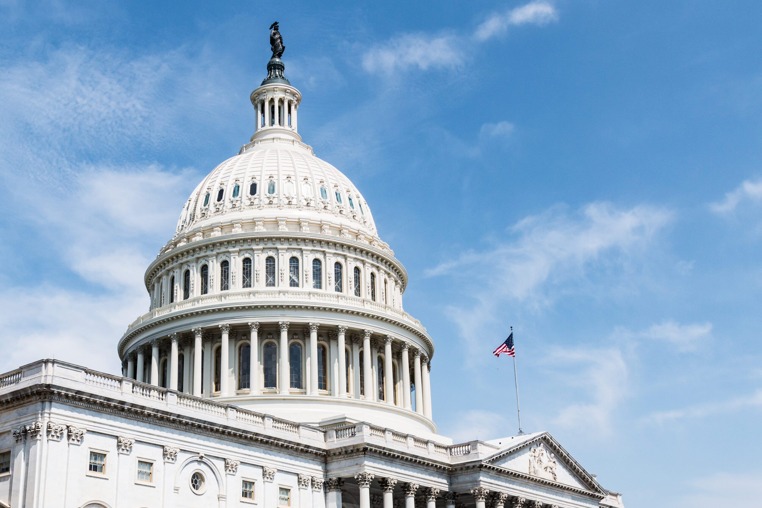Image of the US Capitol dome in front of a blue sky.