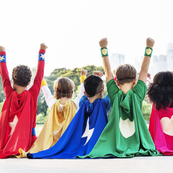 Superhero kids wearing capes and other superhero items.