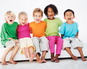 Five diverse children sitting and smiling