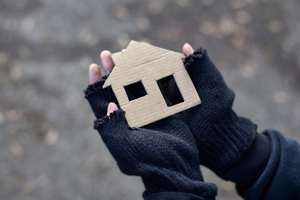 homeless-boy-holding-cardboard-house