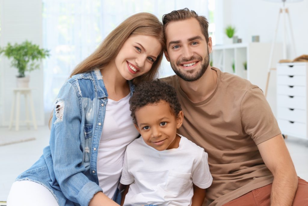 Happy-couple-with-adopted-African-American-boy-at-home-Image